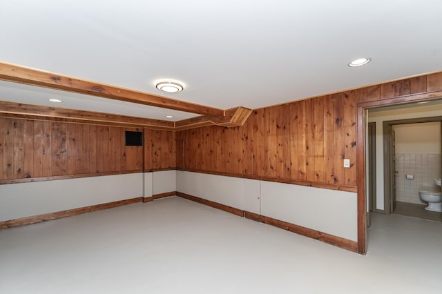 finished below grade area featuring recessed lighting, wood walls, and baseboards