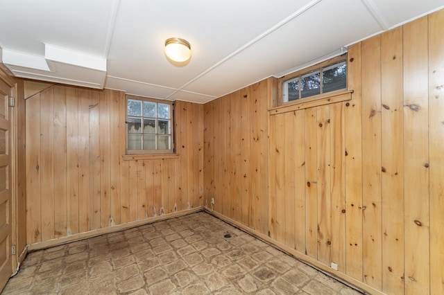 basement with wood walls and tile patterned floors