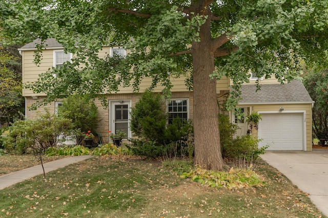 view of front of property featuring concrete driveway, roof with shingles, and an attached garage