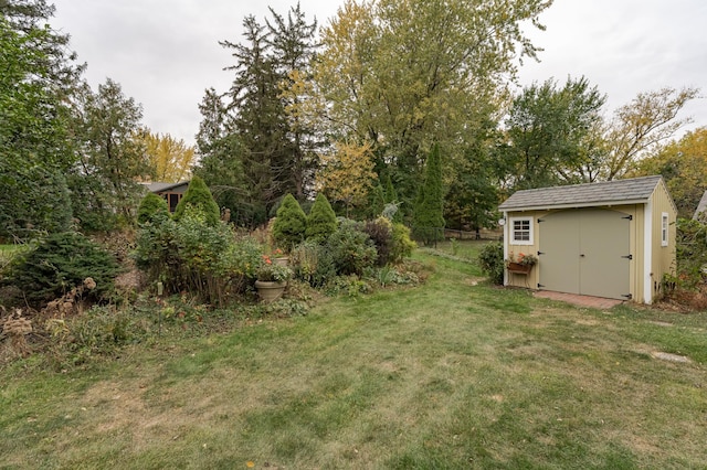 view of yard with an outbuilding, fence, and a shed