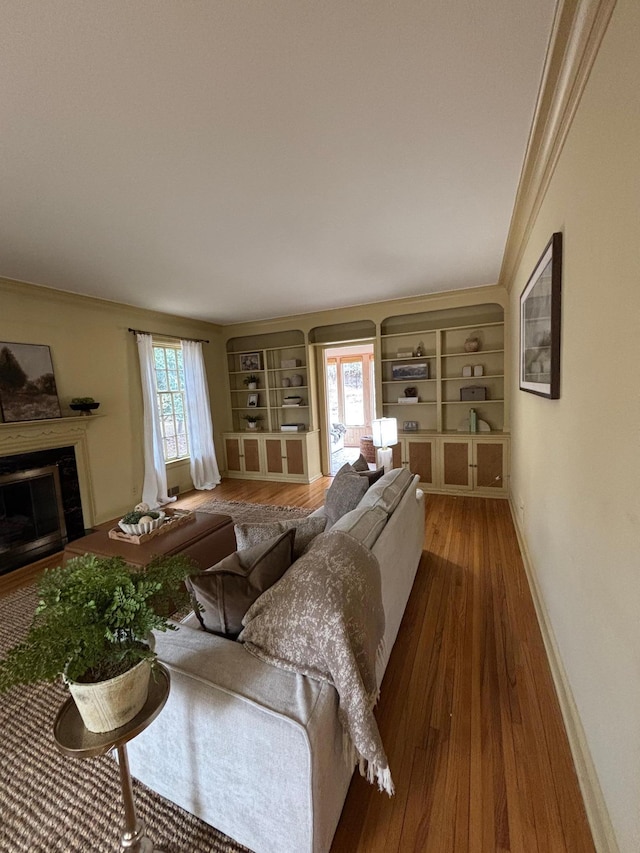 1130 6th St SW, Rochester, MN 55902 - living area with wood finished floors, baseboards, built in features, a fireplace, and crown molding