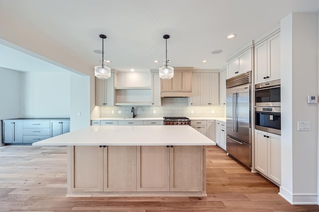 kitchen featuring backsplash, decorative light fixtures, stainless steel appliances, and a center island