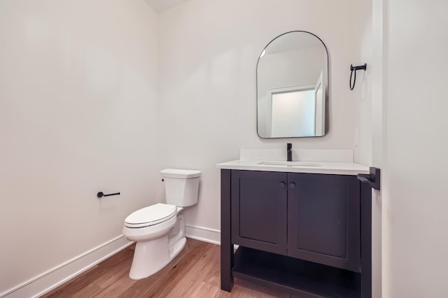 bathroom featuring vanity, toilet, and hardwood / wood-style floors