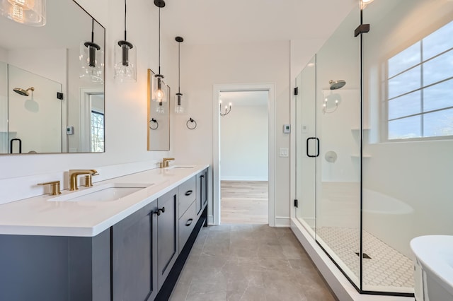 bathroom featuring a shower with door and vanity