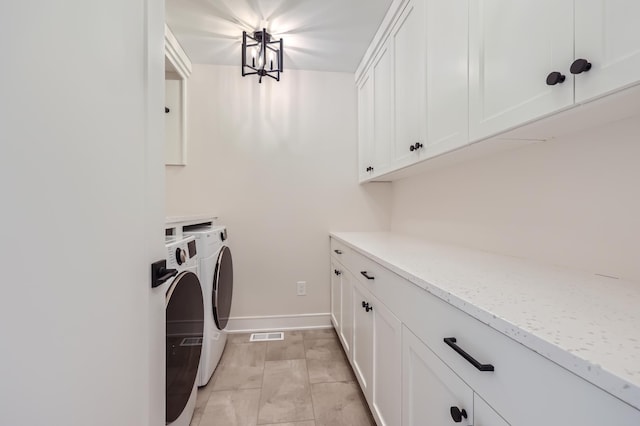 clothes washing area with cabinets and separate washer and dryer