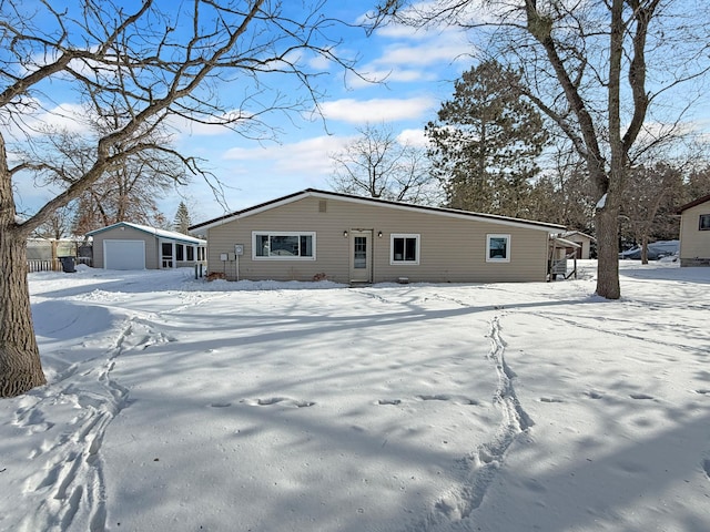 view of front of house with a garage and an outbuilding