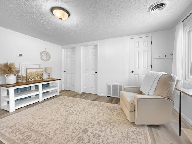 sitting room with a textured ceiling and wood-type flooring