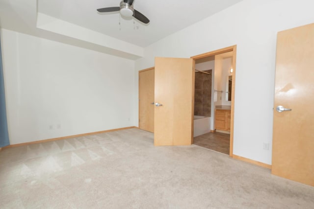 unfurnished bedroom featuring ensuite bath and light carpet