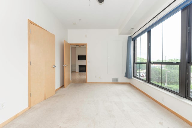 unfurnished room with ceiling fan and light colored carpet