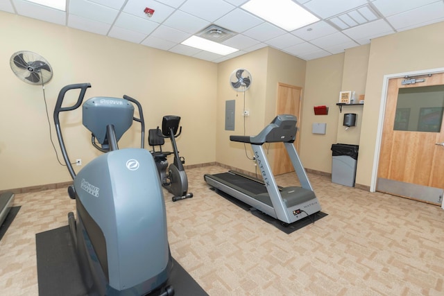 exercise area featuring a paneled ceiling and electric panel