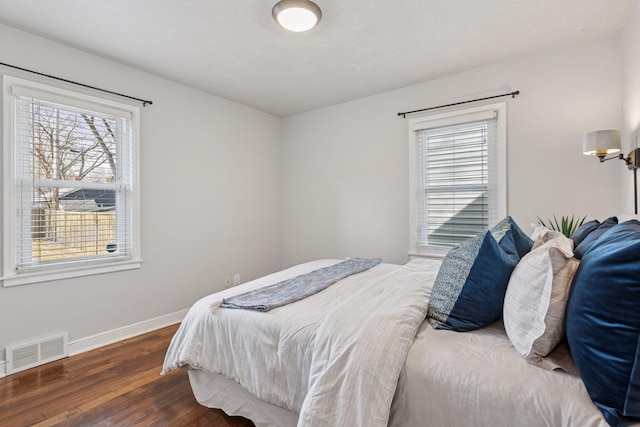 bedroom featuring visible vents, baseboards, and wood finished floors