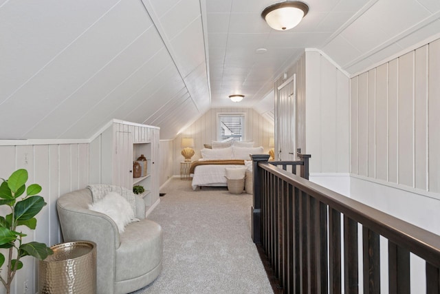 bedroom with carpet, wooden walls, and vaulted ceiling