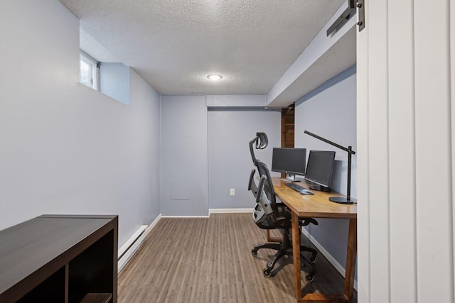 home office featuring baseboards, baseboard heating, wood finished floors, and a textured ceiling