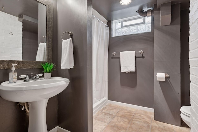 bathroom with tile patterned flooring, baseboards, toilet, and a shower with curtain