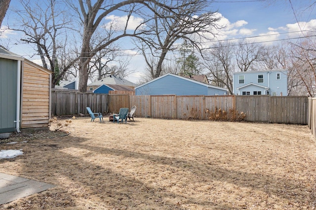 view of yard featuring a fenced backyard and a fire pit