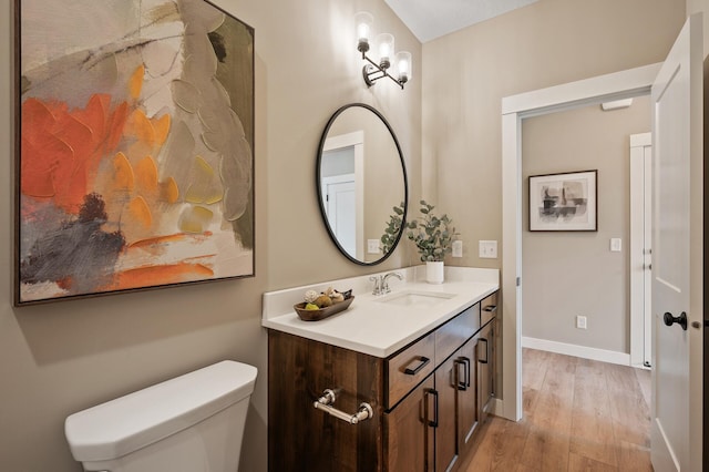 bathroom featuring vanity, hardwood / wood-style floors, and toilet