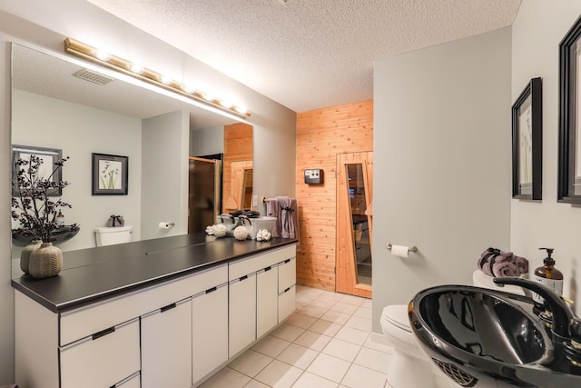 full bathroom with a textured ceiling, wood walls, a sink, and toilet