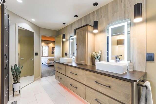 ensuite bathroom featuring double vanity, ensuite bath, a sink, and tile patterned floors