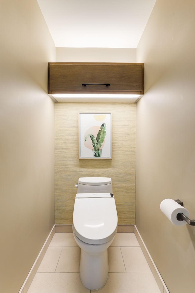 bathroom with baseboards, toilet, and tile patterned floors