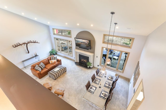 living room featuring recessed lighting, carpet flooring, and a glass covered fireplace