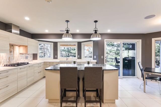 kitchen featuring stainless steel gas cooktop, modern cabinets, a kitchen island, and light tile patterned flooring