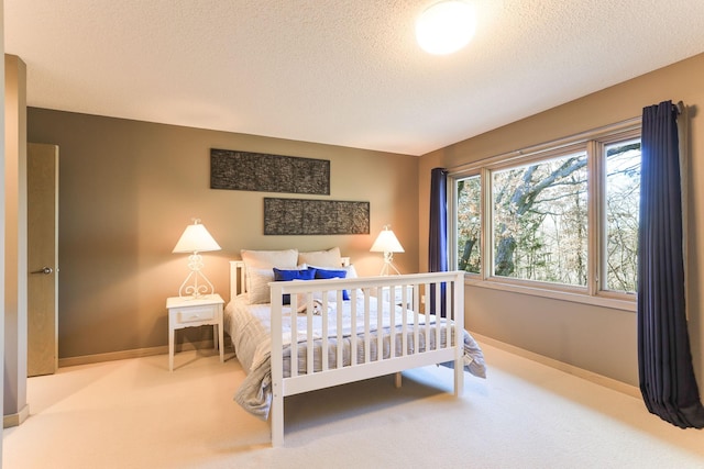 carpeted bedroom featuring a textured ceiling and baseboards