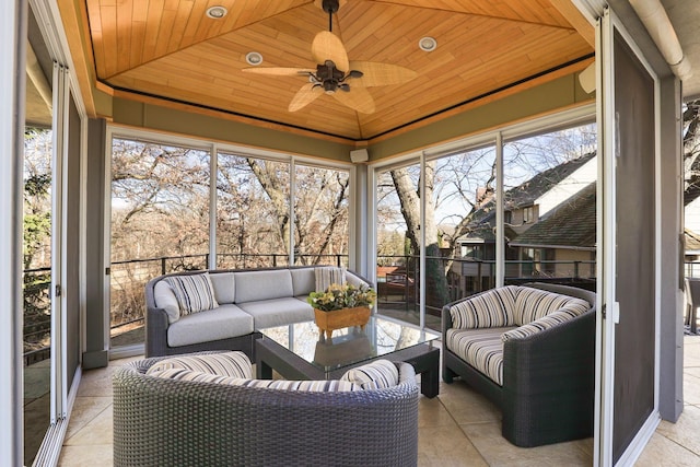 sunroom with wood ceiling, a tray ceiling, vaulted ceiling, and a ceiling fan