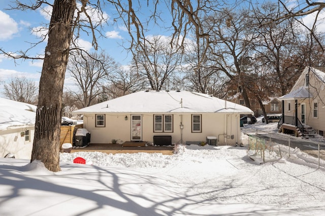 view of front of home with cooling unit, fence, and stucco siding