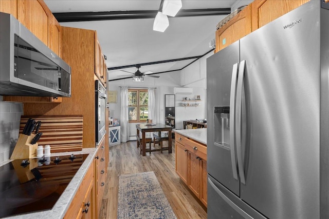 kitchen featuring light countertops, a ceiling fan, appliances with stainless steel finishes, and light wood-style floors