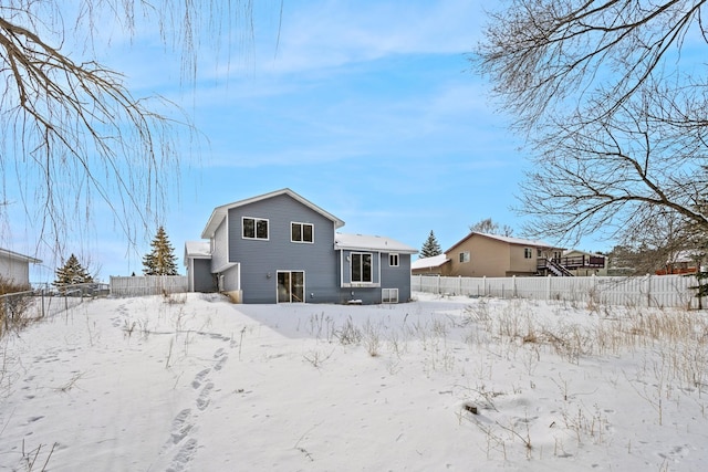 view of snow covered back of property