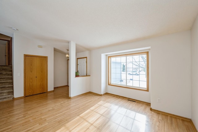 unfurnished room featuring light hardwood / wood-style floors and a textured ceiling