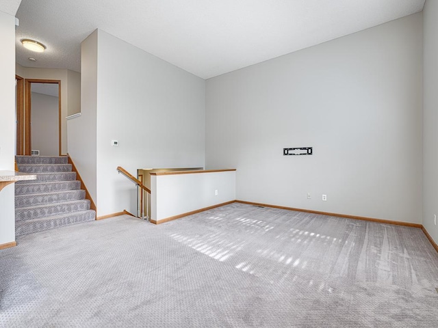 carpeted empty room with a textured ceiling