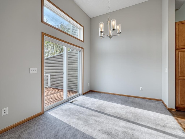 empty room featuring light carpet and a notable chandelier