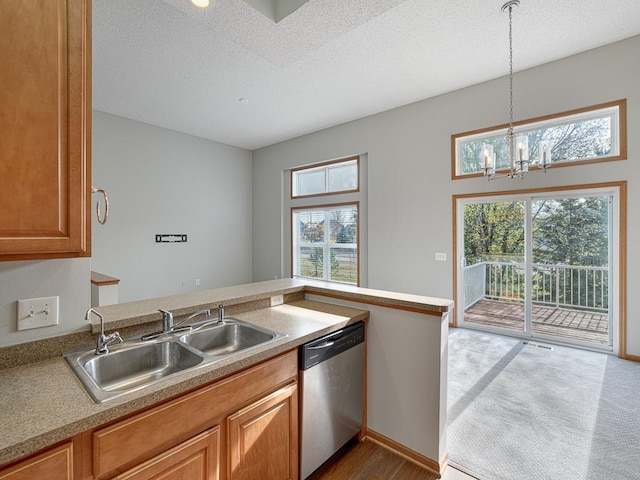 kitchen featuring sink, dishwasher, a textured ceiling, decorative light fixtures, and kitchen peninsula