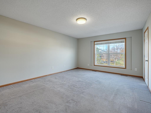 spare room with a textured ceiling and carpet