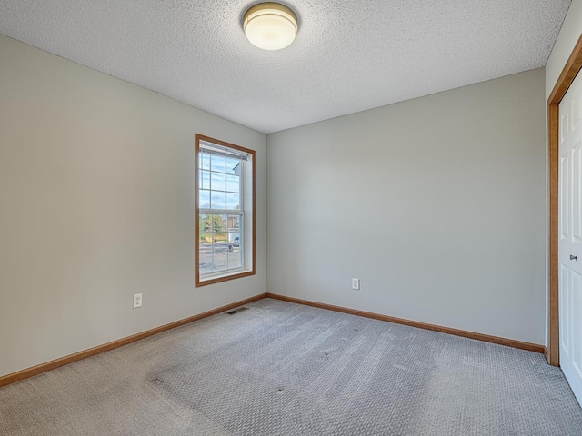 unfurnished room featuring carpet flooring and a textured ceiling