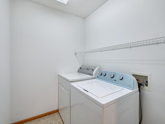 laundry area with separate washer and dryer and a textured ceiling