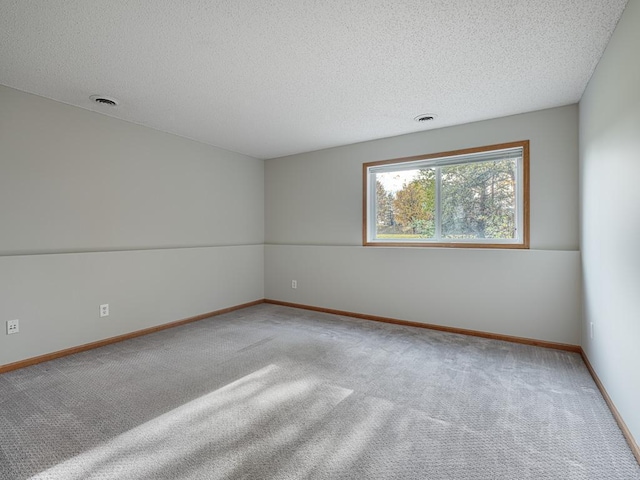 unfurnished room featuring a textured ceiling and carpet