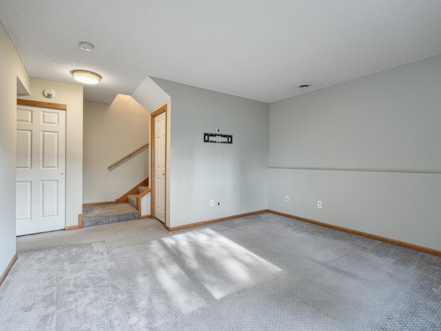 carpeted empty room with a textured ceiling