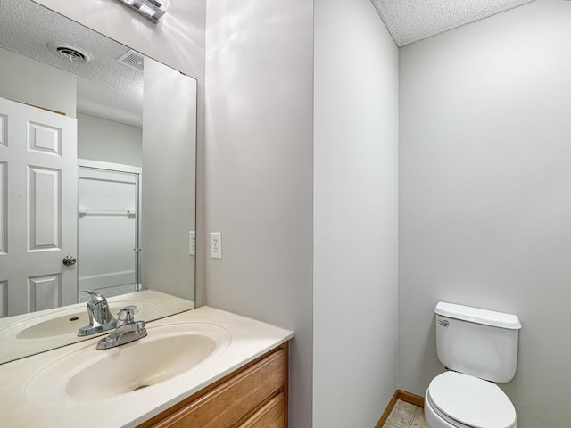 bathroom featuring vanity, toilet, and a textured ceiling