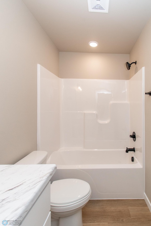 full bathroom featuring vanity, hardwood / wood-style floors, shower / bathtub combination, and toilet