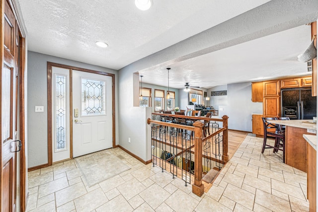 entryway with ceiling fan and a textured ceiling