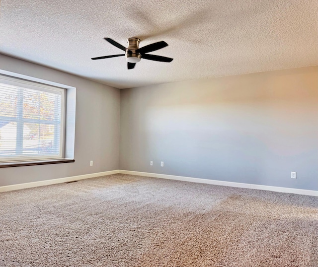 spare room featuring a textured ceiling, ceiling fan, and carpet