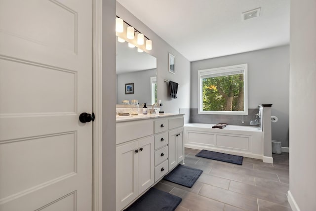 bathroom with vanity, tile patterned flooring, and a bathtub