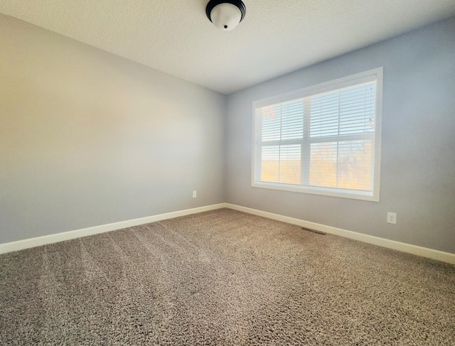 carpeted spare room with a textured ceiling