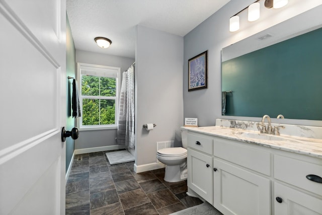 bathroom featuring vanity, a textured ceiling, and toilet