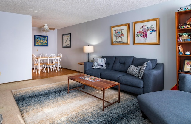 carpeted living area featuring a textured ceiling and a ceiling fan