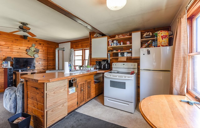 kitchen with ceiling fan, light carpet, white appliances, and wood walls