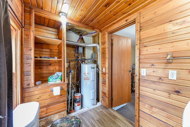 interior space with wood ceiling, water heater, hardwood / wood-style flooring, and wood walls