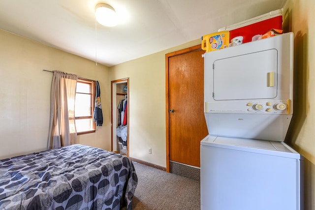 bedroom featuring stacked washer / dryer, carpet flooring, and a closet